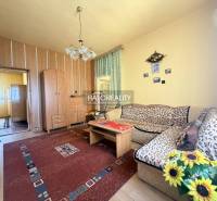 Wohnzimmer in einem Einfamilienhaus mit Holzboden und Blumen.