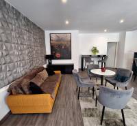 Wohnzimmer in einem Einfamilienhaus mit bequemen Sofa und Essstühlen.