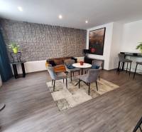 Wohnzimmer mit Sesseln und Sofa in einem Einfamilienhaus, dekorative Wand und Bartheke.