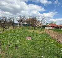 Grundstück auf dem Schwarzen Moor in Pukanec mit gepflegtem Garten und nahegelegenen Häusern.