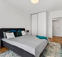 Schlafzimmer in einer 2-Zimmer-Wohnung mit Bett, Nachttisch und Schrank.