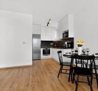 Küche mit Esstisch in einer 2-Zimmer-Wohnung, Boden mit Holzdekor.