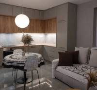 Küche in einer 2-Zimmer-Wohnung mit Holzboden und rundem Tisch.