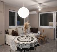 Wohnzimmer mit Sofa, rundem Tisch und dekorativer Leuchte in einer 2-Zimmer-Wohnung.