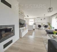 Wohnzimmer mit Kamin, Fernseher und Holzboden in einem Einfamilienhaus.