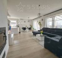 Wohnzimmer in einem Einfamilienhaus mit großem Sofa und Holzboden.