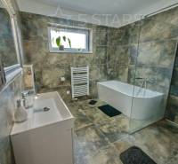 Badezimmer mit Badewanne, Dusche und Fliesen im Einfamilienhaus.