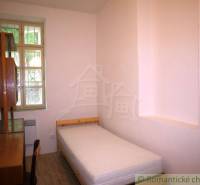 Einfaches Schlafzimmer mit einem Einzelbett und Holzmöbeln in einem Einfamilienhaus.