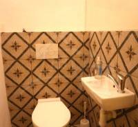 Badezimmer im Einfamilienhaus mit Waschbecken und Toilette mit dekorativen Fliesen.
