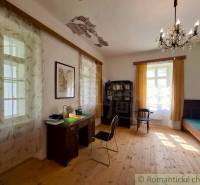 Innenraum eines Einfamilienhauses mit Schreibtisch, Regal und Boden in Holzoptik.