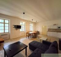 Wohnzimmer mit Küche im Einfamilienhaus, Holzboden, Esstisch, Sofa.