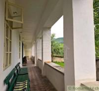 Veranda mit Bank bei einem Einfamilienhaus in Dobroč, Blick auf den Garten und die Bäume.