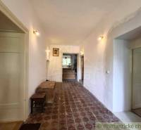 Der Flur in einem Einfamilienhaus mit gemusterten Fliesen, hell, Holztüren, Bilder an der Wand.