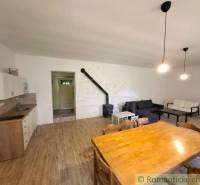 Wohnzimmer in einem Einfamilienhaus mit Holzboden, Kamin und Sofas.