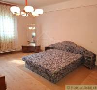 Ein Zimmer in einem Einfamilienhaus mit Teppichmöbeln und einem Spiegel, Holzboden mit Holzdekor.