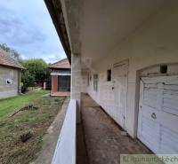 Ein Einfamilienhaus in Mužla mit Veranda und Garten, im ländlichen Stil und einfacher Architektur.