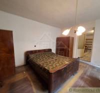 Schlafzimmer in einem Einfamilienhaus mit Holzschränken und Boden mit Holzdekor.