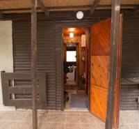Eingang zur Hütte mit aufklappbaren Holztüren und Veranda auf Freizeitgrundstücken.