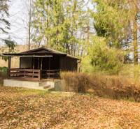 Eine Hütte umgeben von Wald auf Erholungsgrundstücken in Holčíkovce im Herbst.