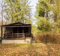 Eine Holzhütte umgeben von Bäumen auf Erholungsgrundstücken in Holčíkovce.