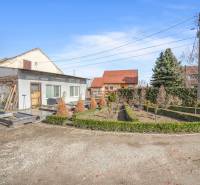 Gewerberäume in Okoč mit Gartenanlage, umgeben von Bäumen und Sträuchern.