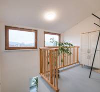 Fenster mit Holzrahmen, Geländer, Pflanze, weiße Möbel in einer 2-Zimmer-Wohnung.