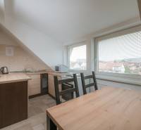 Küche in einer 2-Zimmer-Wohnung mit Holzboden, große Fenster mit Aussicht.