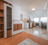Wohnzimmer mit Holzboden und Küche in einer 2-Zimmer-Wohnung.