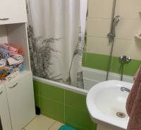 Badezimmer mit Badewanne und bunten Fliesen in einer 2-Zimmer-Wohnung.