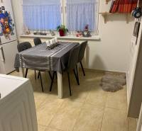 Essbereich in einer Zweizimmerwohnung mit einem weißen Tisch und grauen Stühlen.