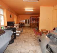 Innenraum von Gastronomiebereichen mit orangefarbenen Wänden, Lagerraum mit Stühlen und Ausstattung.