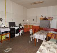 Innenraum von Gastronomiebereichen mit ausgestatteter Küche und Sofa, Boden mit Holzdekor.