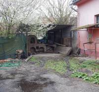 Außenbereich in den Gastronomieräumen in Búč mit einem alten Ofen und Frühlingsvegetation.