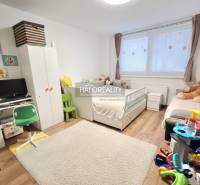Kinderzimmer mit weißen Möbeln, Teppich und Boden mit Holzdekor in einer 3-Zimmer-Wohnung.