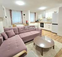 Das Wohnzimmer mit Küche in der 3-Zimmer-Wohnung verbindet ein bequemes Sofa und eine Küchenzeile.