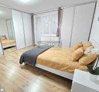 Helles Schlafzimmer in einer 3-Zimmer-Wohnung mit großem Einbauschrank und Boden in Holzoptik.