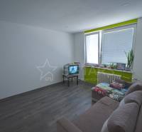 Wohnzimmer in einer Einzimmerwohnung mit Holzboden und hellen Wänden.