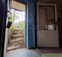 Die Türen, die von der Hütte in den Garten mit Blättern und Betontreppen in Kamenín führen.