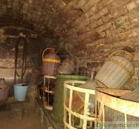 Weinkeller in der Hütte mit Steinen und Demijohns in Kamenín.