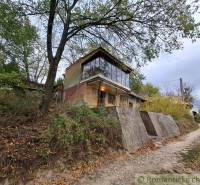Eine Hütte in Kamenín, umgeben von Natur, Bäumen und einem Weg.