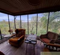 Eine Hütte mit Blick auf die Natur, bequeme Sessel und ein Boden mit Holzdekor.