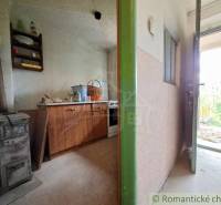 Innenraum einer Hütte mit einem alten Ofen und Möbeln auf einem Boden mit Holzdekor.