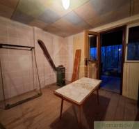 Innenraum einer Hütte mit Holzboden und alten Möbeln.