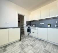 Küche in einer 2-Zimmer-Wohnung mit grauem Boden in Holzoptik und weißen Schränken.
