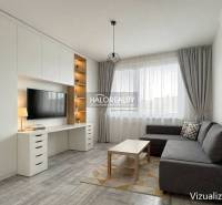 Wohnzimmer mit Ecksofa, Fernseher an der Wand und Holzboden in einer Zweizimmerwohnung.