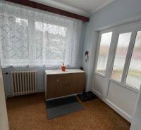 Innenraum eines Einfamilienhauses mit Teppich, Heizkörper und Schrank unter dem Fenster.