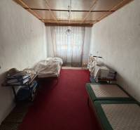 Ein Zimmer in einem Einfamilienhaus mit rotem Teppich und Betten auf beiden Seiten.