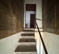 Eine Treppe in einem Einfamilienhaus mit einem Holzgeländer, die in den ersten Stock führt.