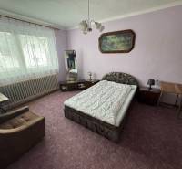 Schlafzimmer mit Bett, Sessel und Bild im Einfamilienhaus.