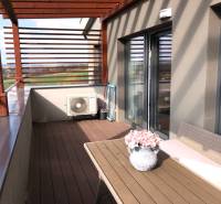 Die Terrasse einer 2-Zimmer-Wohnung mit Blick auf die Umgebung und Blumendekoration.